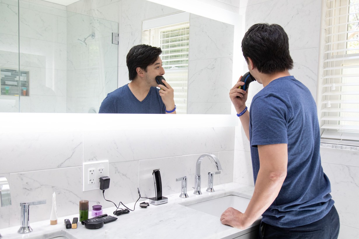 a man shaving in front of a mirror