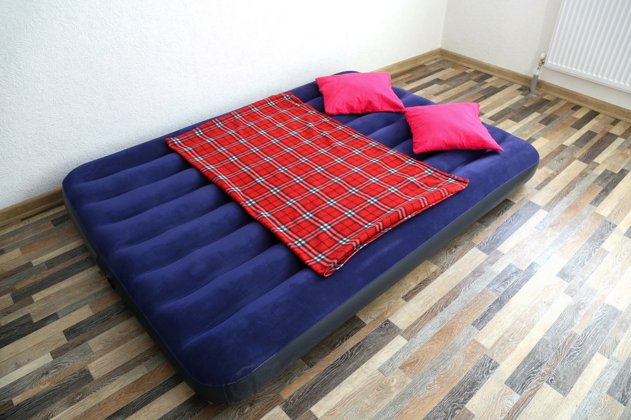 an air mattress with pillows and a blanket
