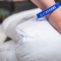a hand on top of a white comforter