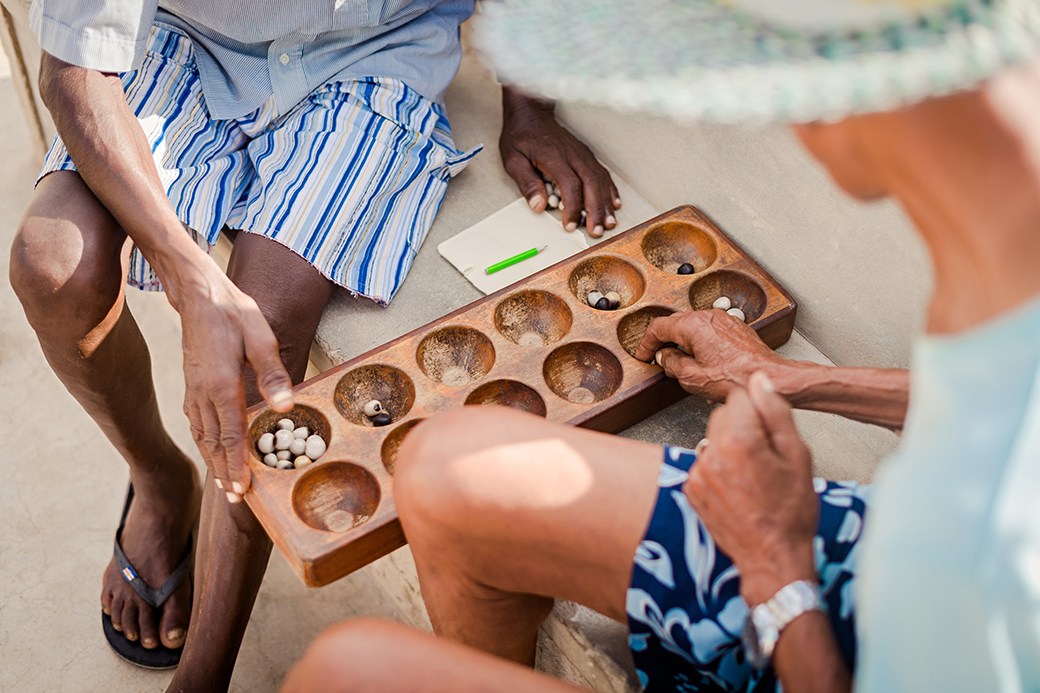 Two people playing Mancala outdoors