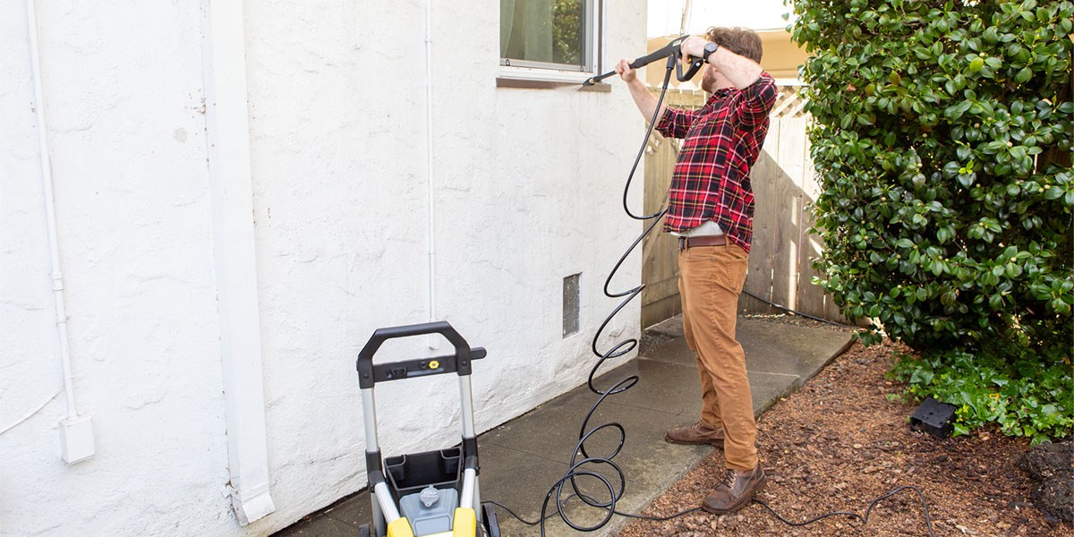 Person uses Kärcher K1700 Pressure Washer to wash outside of home