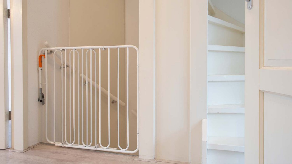A baby gate closing access to a staircase 