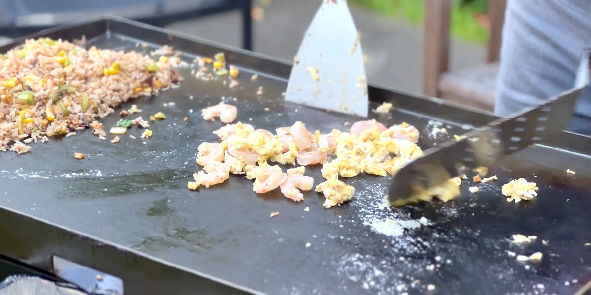 Person cooking on flat-top grill