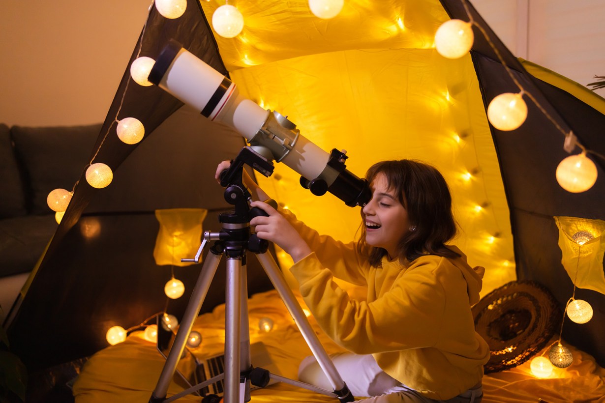 a girl looking through a telescope