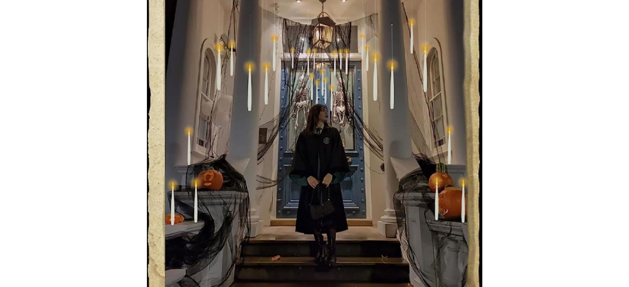 Woman in black standing beneath floating candles